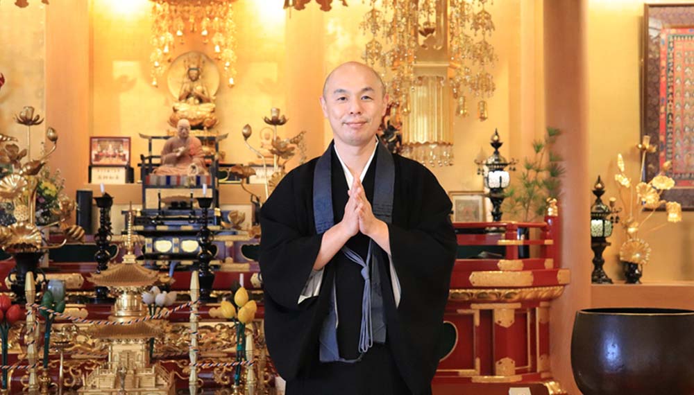神々しい豪華な仏壇の前で手を合わせる僧侶