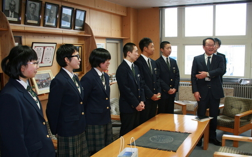 3名の女子中学生、3名の男子中学生、2名の男性が並んで立って挨拶をしている写真