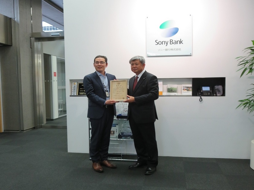 佐藤町長からソニー銀行株式会社代表取締役副社長へ、感謝状を贈呈する場面を捉えた写真