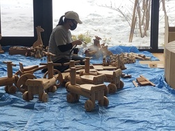女性が木製の遊具を抗菌施工している写真
