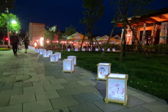 夜に芝生の横のレンガ道に模様のあるランタンが並べられているイベントの写真
